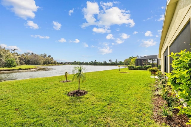 view of yard with a lanai and a water view