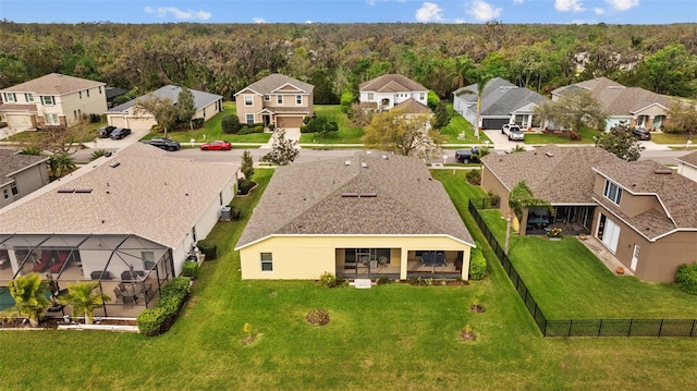 drone / aerial view featuring a residential view and a wooded view