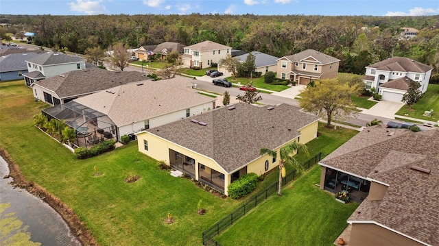 drone / aerial view featuring a residential view and a wooded view