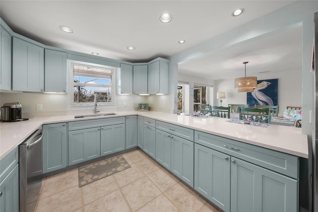 kitchen with a peninsula, a sink, light countertops, stainless steel dishwasher, and recessed lighting