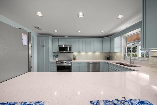 kitchen featuring visible vents, light stone countertops, stainless steel appliances, a sink, and recessed lighting