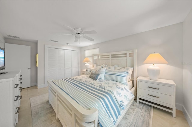 bedroom featuring a closet, visible vents, baseboards, and light tile patterned floors