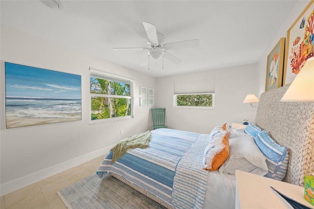 bedroom with ceiling fan, tile patterned flooring, and baseboards