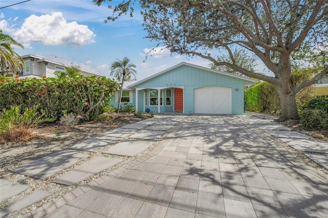 ranch-style home featuring concrete driveway and an attached garage