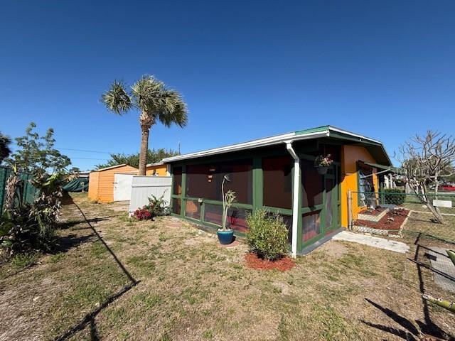 view of side of property with an outbuilding and fence