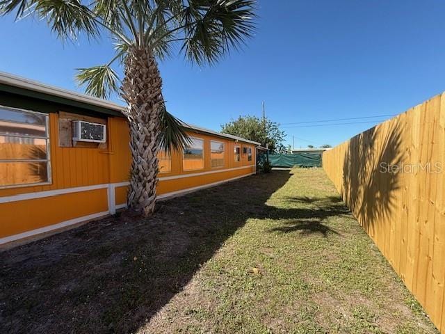 view of yard featuring a wall mounted AC and a fenced backyard