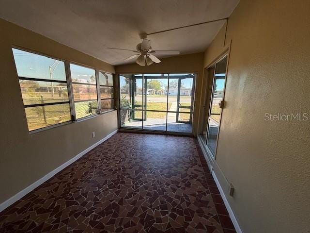 unfurnished sunroom with ceiling fan