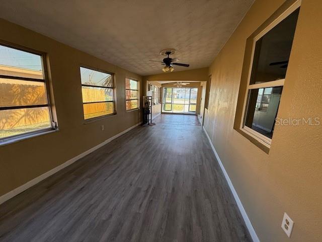 unfurnished sunroom with a ceiling fan