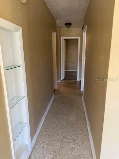 corridor featuring baseboards