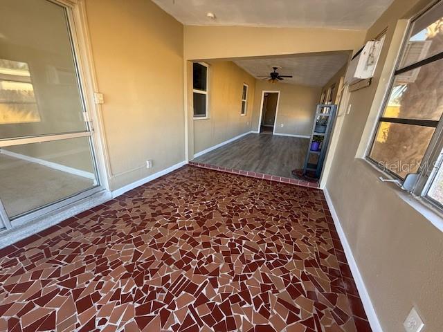 corridor with lofted ceiling and baseboards