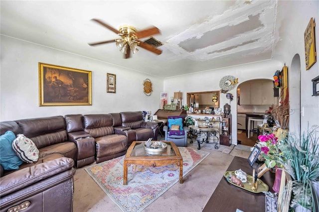 living room with arched walkways, visible vents, and ceiling fan