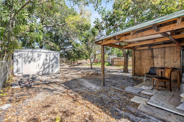 view of yard with a storage shed, fence, a patio, and an outbuilding