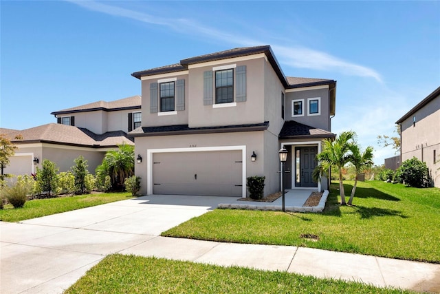 view of front of home featuring a front lawn, an attached garage, driveway, and stucco siding