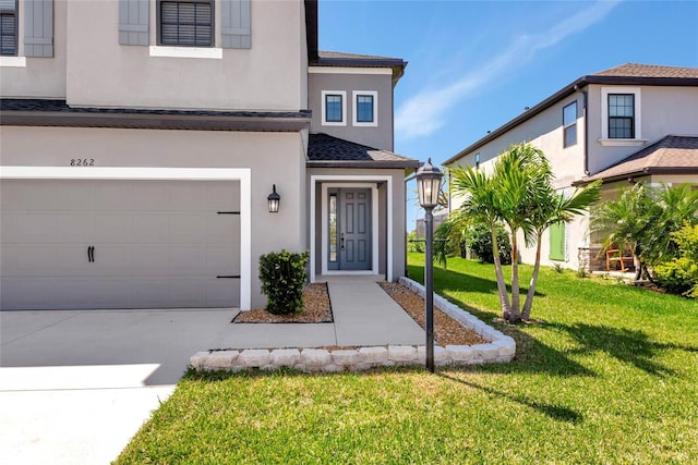 doorway to property featuring stucco siding, a lawn, roof with shingles, concrete driveway, and an attached garage