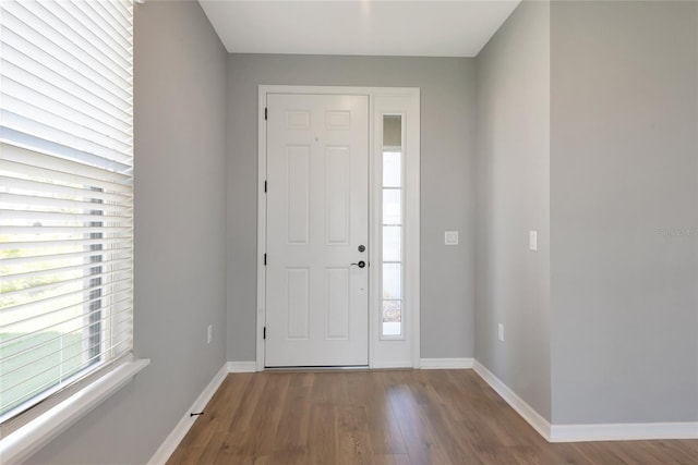 foyer featuring baseboards and wood finished floors