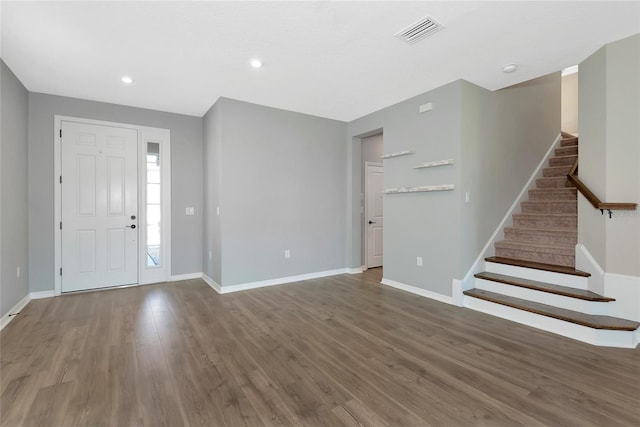 entrance foyer featuring stairway, wood finished floors, visible vents, and baseboards