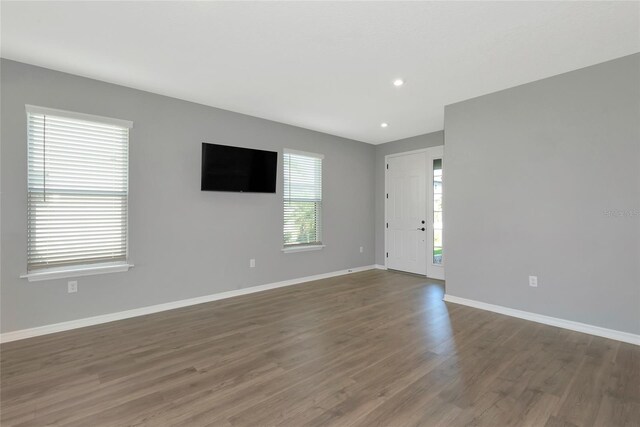 spare room featuring recessed lighting, baseboards, and wood finished floors