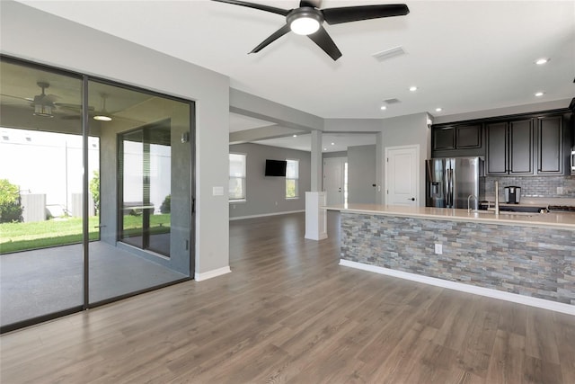 kitchen with visible vents, light wood-type flooring, light countertops, stainless steel fridge, and backsplash