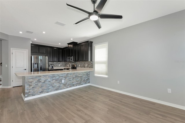 kitchen featuring visible vents, backsplash, light countertops, stainless steel appliances, and a sink