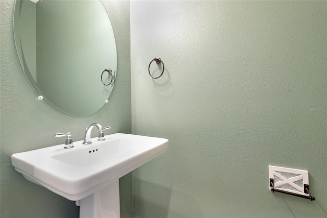 bathroom with a sink and a textured wall