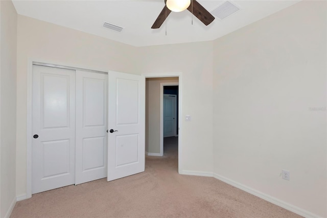 unfurnished bedroom with visible vents, baseboards, light colored carpet, and a closet