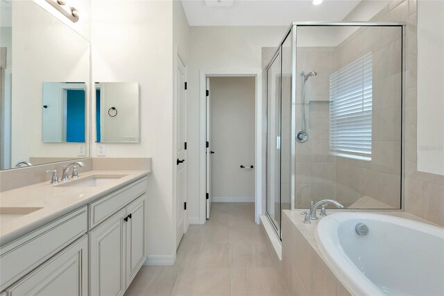 full bathroom with baseboards, double vanity, a stall shower, a bath, and a sink