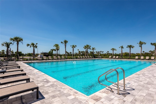 community pool with fence and a patio area