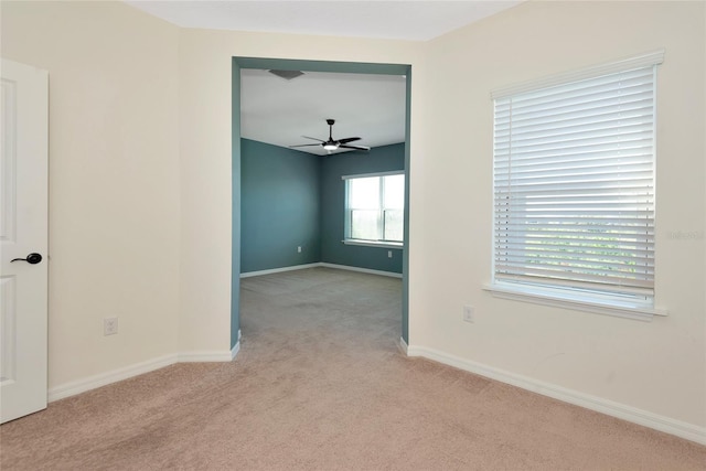 spare room featuring carpet flooring, baseboards, and ceiling fan