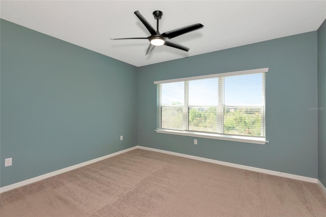 unfurnished room with light carpet, a ceiling fan, and baseboards