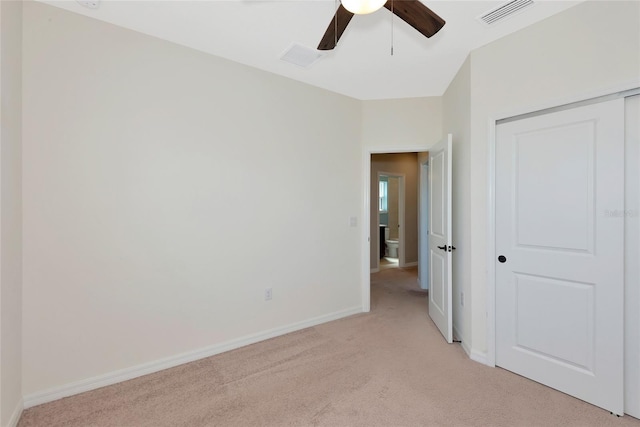 unfurnished bedroom with light colored carpet, visible vents, a closet, and baseboards