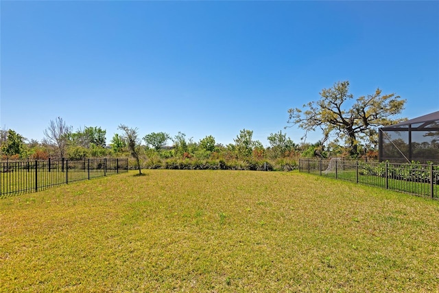 view of yard with a lanai and fence