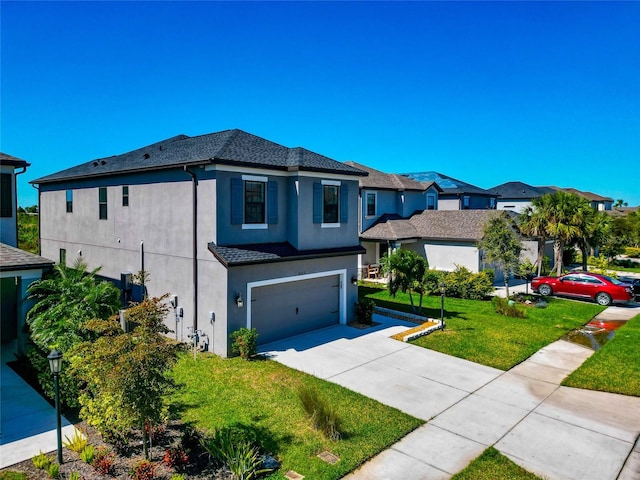 view of front facade with stucco siding, an attached garage, concrete driveway, and a front lawn