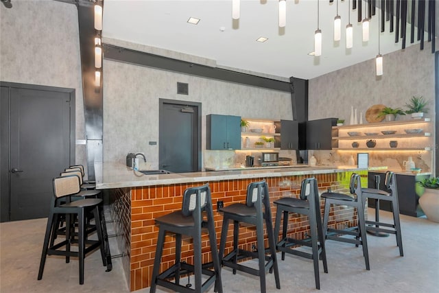 kitchen with visible vents, a sink, a breakfast bar, concrete flooring, and open shelves