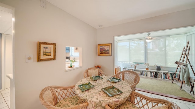 dining area with tile patterned flooring, a ceiling fan, and lofted ceiling