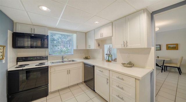 kitchen with black appliances, light tile patterned floors, light countertops, and a sink