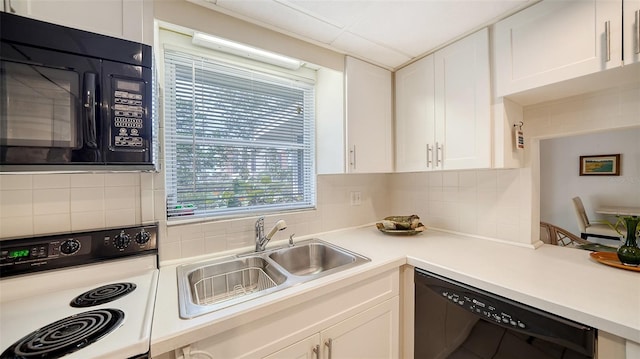 kitchen featuring black appliances, a sink, backsplash, white cabinetry, and light countertops