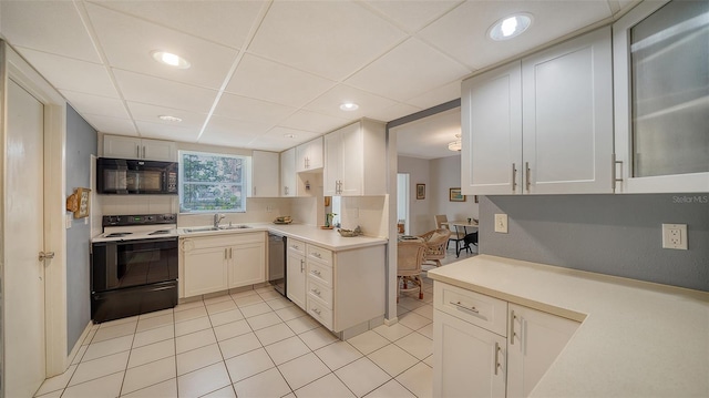 kitchen with dishwashing machine, a sink, electric range oven, light countertops, and black microwave