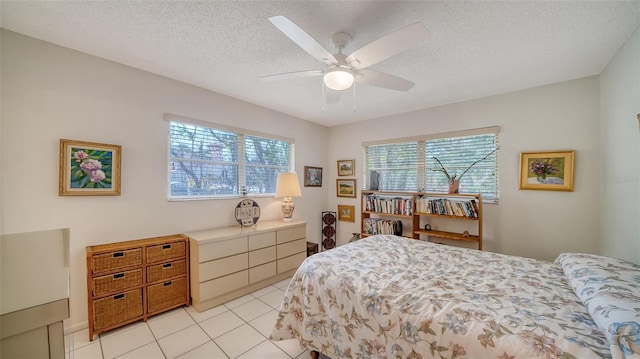 bedroom with multiple windows, light tile patterned flooring, and a textured ceiling