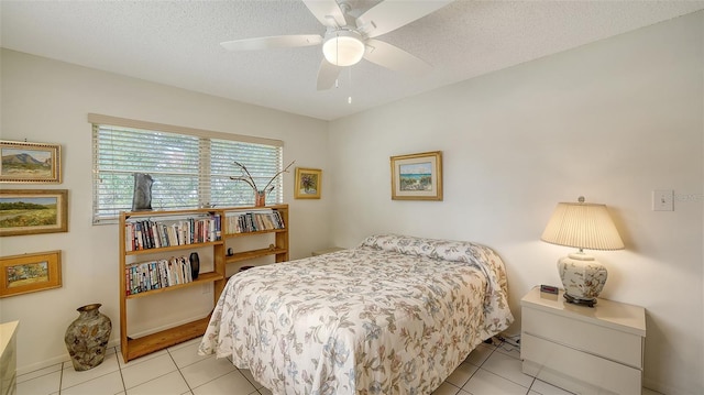 bedroom with light tile patterned floors, a ceiling fan, baseboards, and a textured ceiling