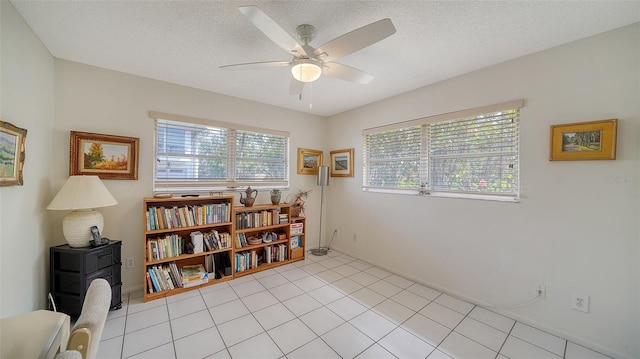 interior space featuring ceiling fan, light tile patterned flooring, and a textured ceiling