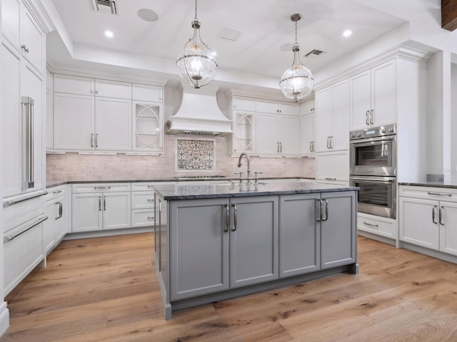 kitchen featuring visible vents, appliances with stainless steel finishes, gray cabinetry, and custom range hood