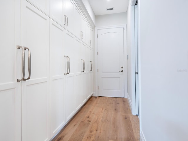 corridor with visible vents and light wood-style floors