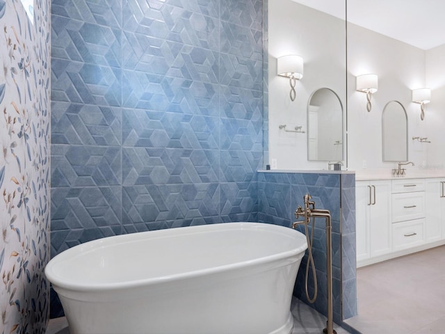 bathroom featuring a soaking tub, tile walls, and vanity