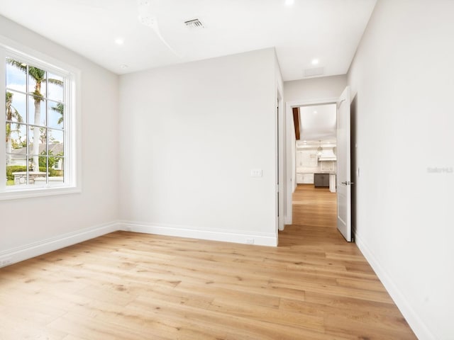 spare room featuring recessed lighting, light wood-style floors, visible vents, and baseboards