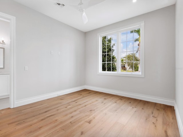 empty room featuring visible vents, baseboards, and light wood finished floors