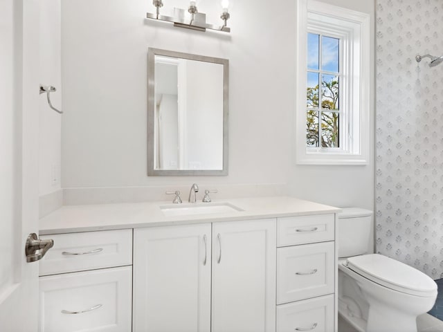 bathroom with wallpapered walls, curtained shower, toilet, and vanity