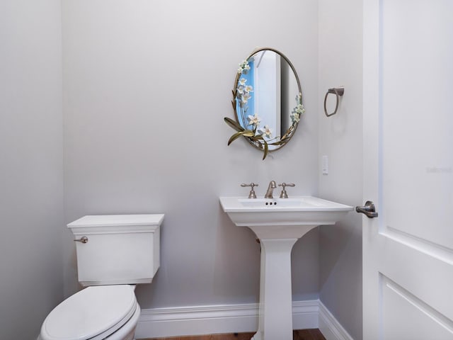 bathroom with toilet and baseboards