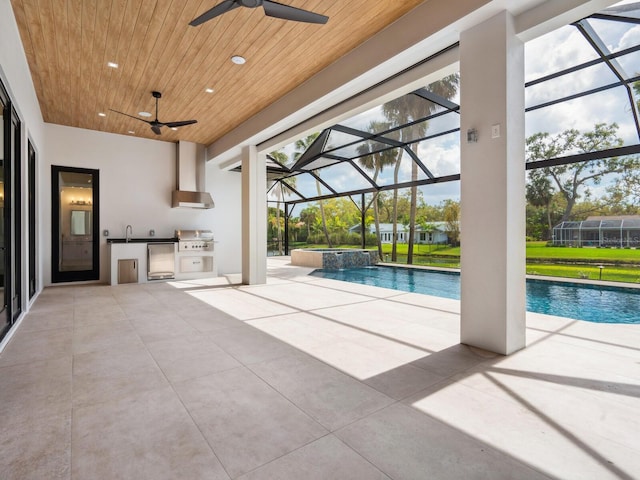 view of pool featuring a lanai, exterior kitchen, a sink, and a patio area