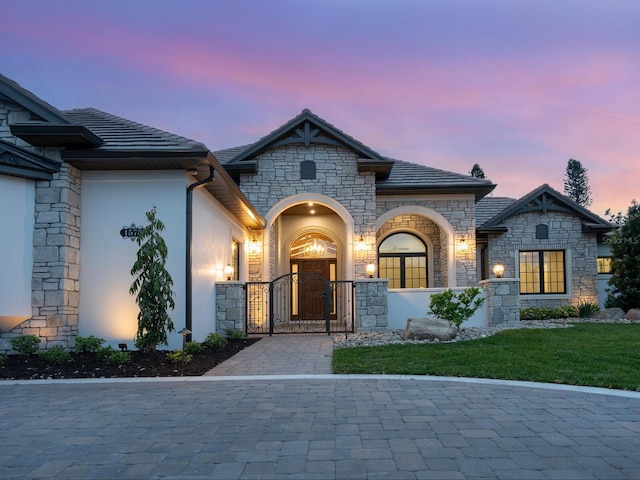 french country style house featuring a gate and stucco siding