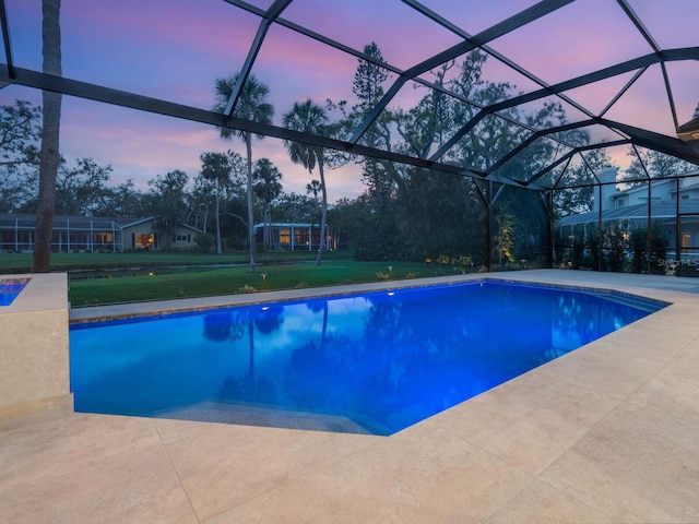 pool at dusk featuring a lanai, a lawn, an outdoor pool, and a patio